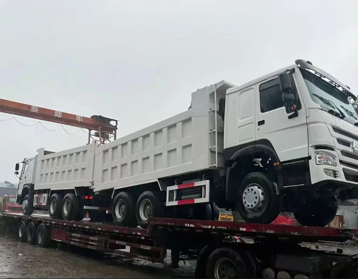 HOWO 6x4 dump trucks loaded on a trailer for dispatch to Qingdao Port